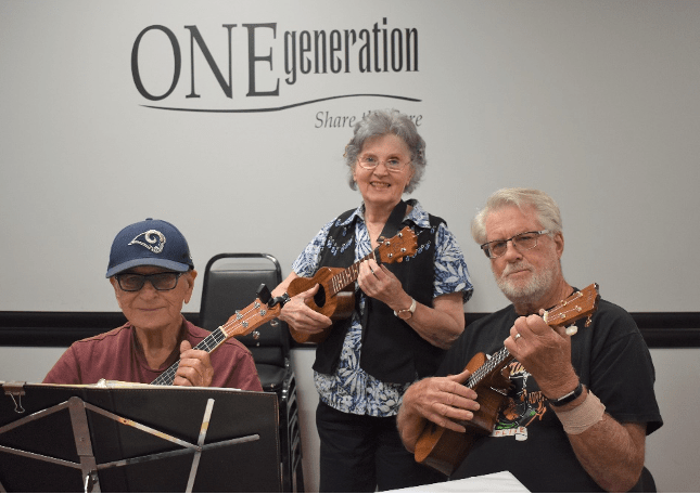 Seniors in front of sheet music with ukeleles